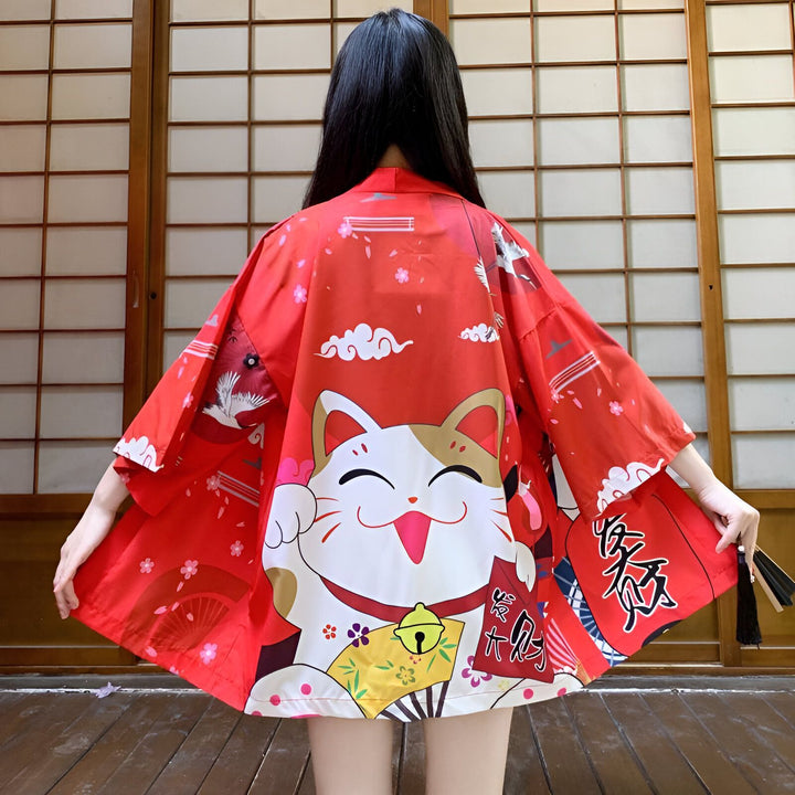 Kimono rouge avec motif de chat porte-bonheur japonais Maneki Neko. Vêtement traditionnel japonais, idéal pour un look unique et tendance. Découvrez notre collection de kimonos.