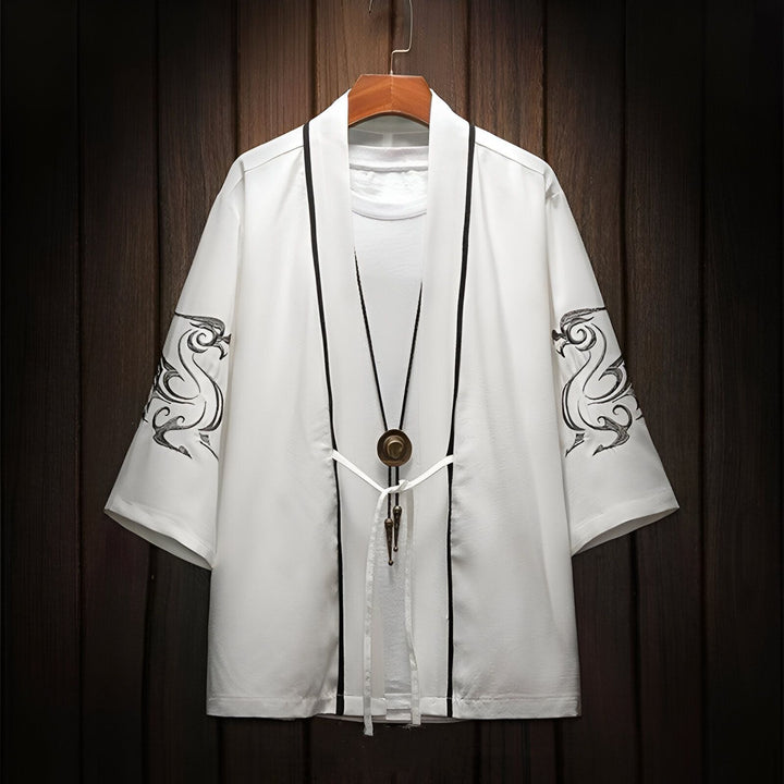 Kimono blanc avec motifs de dragons noirs sur les manches, suspendu à un cintre. Vêtement de style japonais en vente.