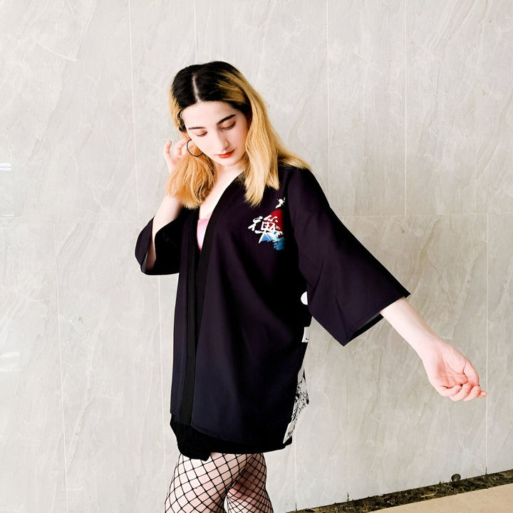 Femme portant un kimono noir avec broderie japonaise. Kimono ample et élégant. Découvrez notre collection de kimonos uniques.