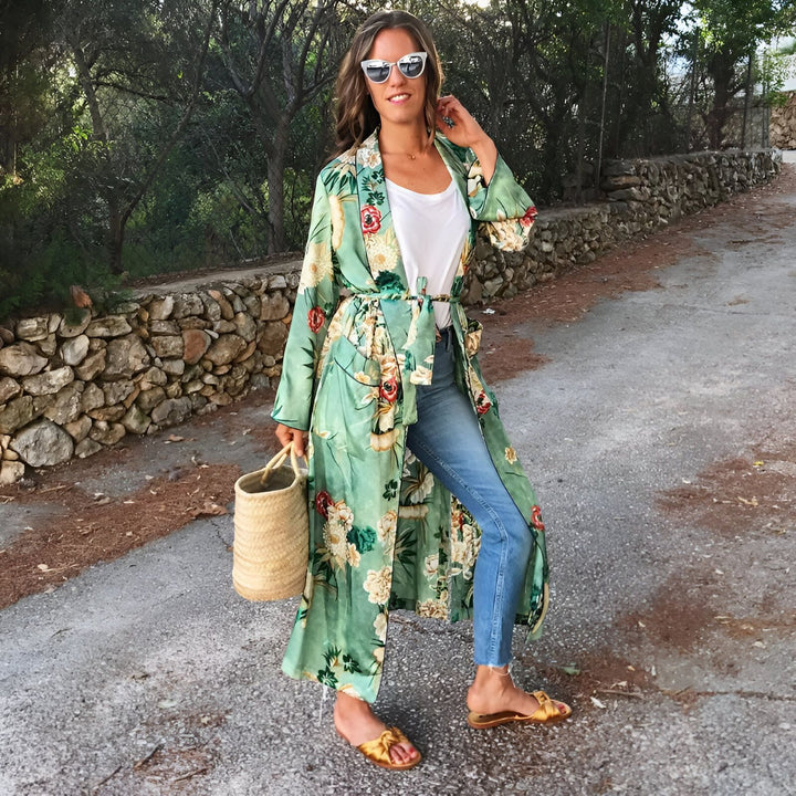Femme portant un kimono long à motifs floraux verts. Kimono tendance, parfait pour l'été. Disponible dans notre boutique en ligne.