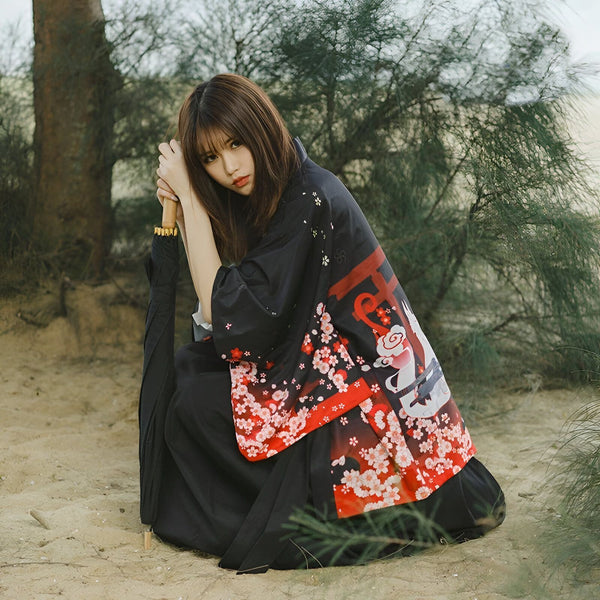 Femme portant un kimono noir avec des motifs floraux rouges et blancs. Kimono japonais traditionnel. Vêtements de style japonais.