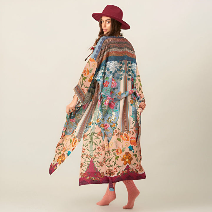 Femme portant un kimono long et coloré avec un chapeau bordeaux. Kimono avec motifs floraux et ceinture. Vêtements de style kimono.