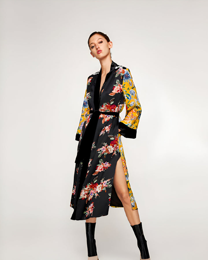 Femme portant un kimono fleuri noir et jaune avec une ceinture noire. Kimono élégant et tendance, parfait pour toutes les occasions. Découvrez notre collection de kimonos uniques.