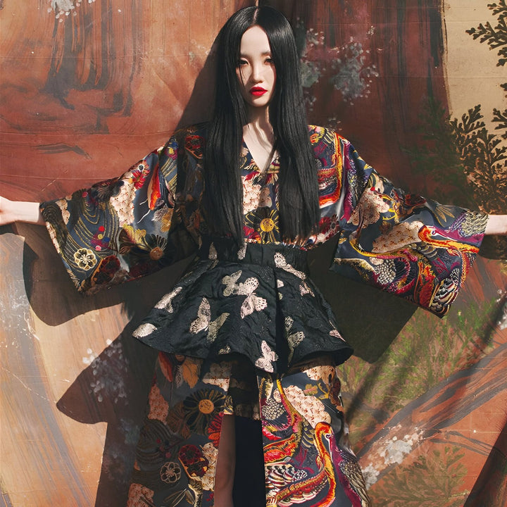 Femme asiatique portant un kimono long imprimé fleuri et animalier avec une jupe courte noire à motifs papillons. Style élégant et traditionnel revisité. Kimonos à vendre en ligne.