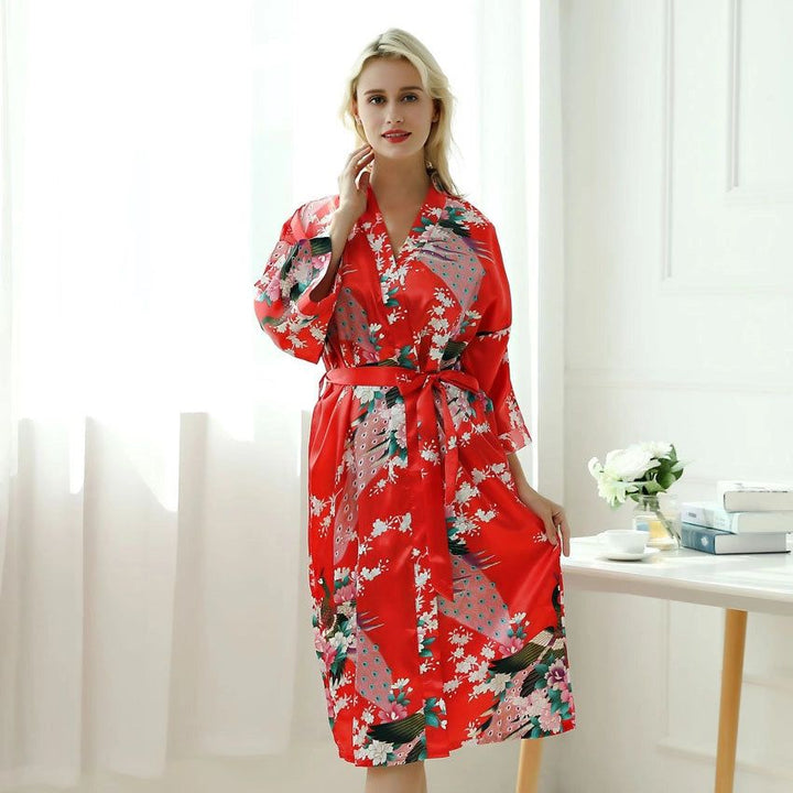 Femme portant un kimono rouge avec motifs de paons et de fleurs. Kimonos élégants pour femmes disponibles à l'achat.
