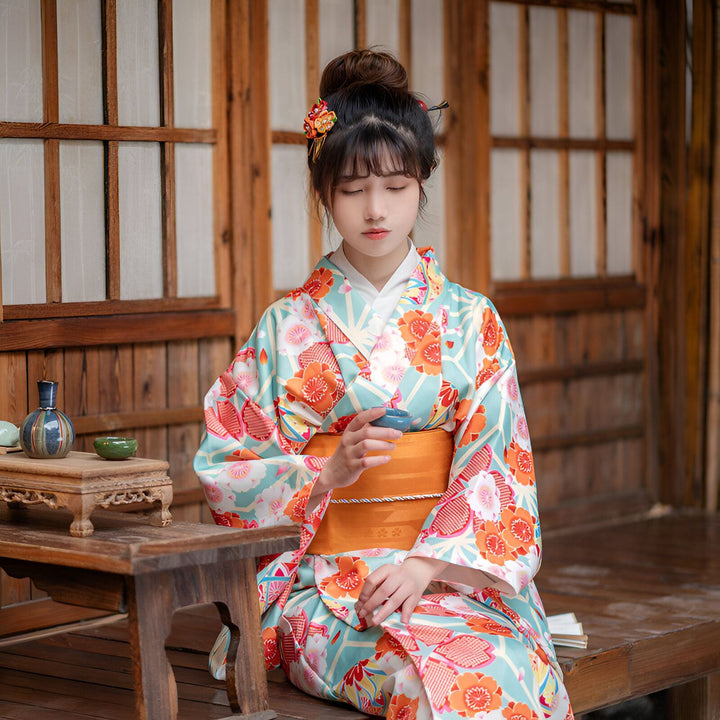 Femme portant un kimono fleuri traditionnel japonais bleu et orange. Vente de kimonos authentiques.