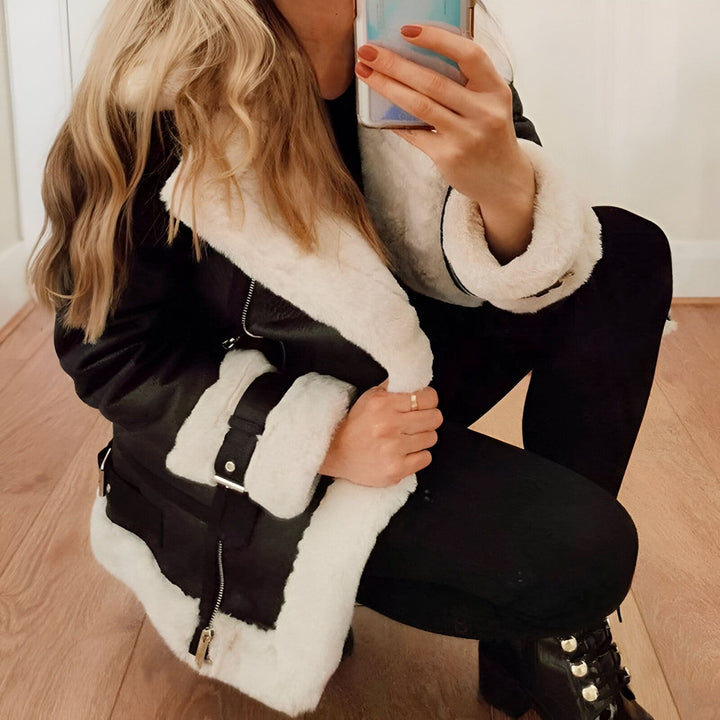 Femme accroupie portant un manteau d'hiver noir avec bordure en fausse fourrure blanche. Mode d'hiver confortable. Découvrez notre collection de kimonos et vestes.