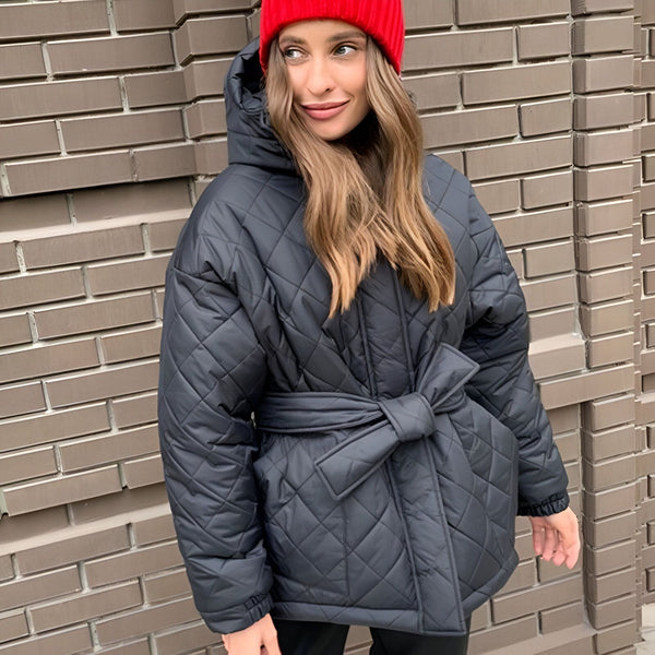 Femme portant un manteau kimono matelassé noir avec une ceinture, coiffée d'un bonnet rouge. Vêtements de style kimono tendance.