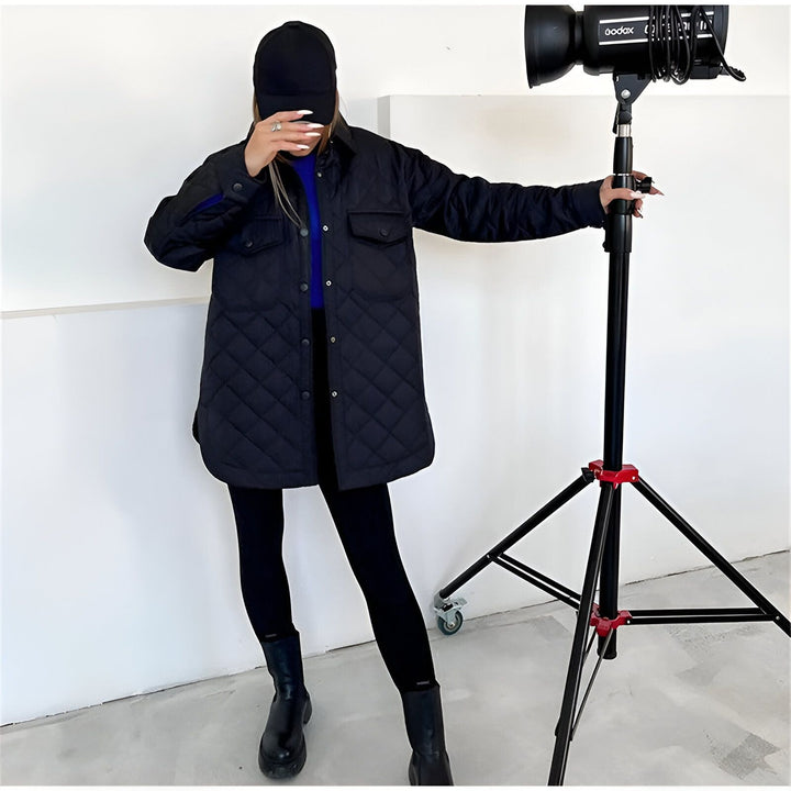 Femme portant un kimono matelassé noir, casquette noire et bottes noires. Shooting photo en studio avec lumière professionnelle. Découvrez notre collection de kimonos.