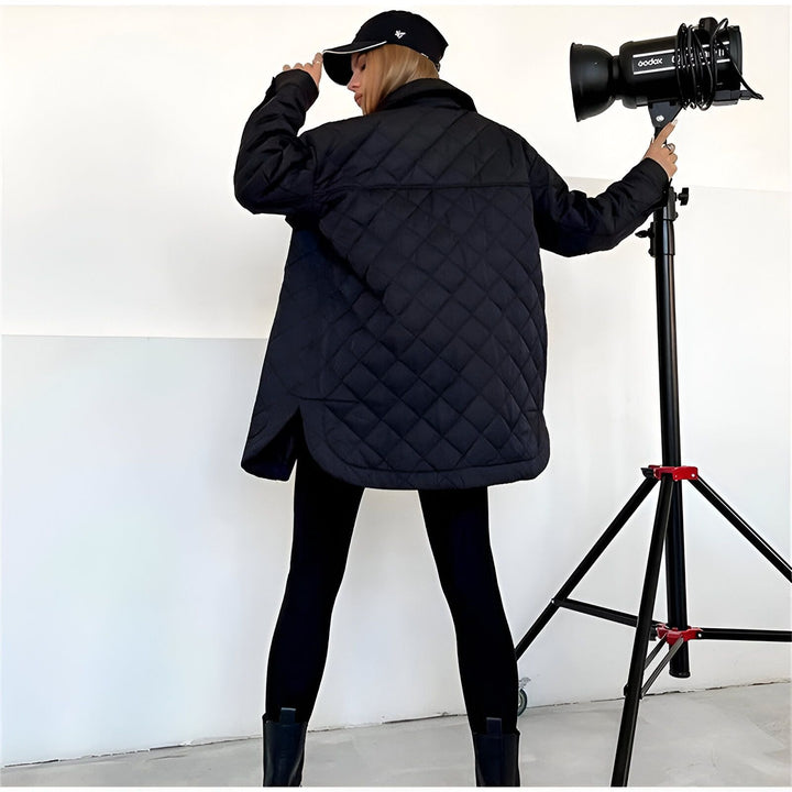 Femme portant une veste kimono noire matelassée. La veste est moderne et élégante. Elle a un motif de losanges et des poches. Vêtements de style kimono.