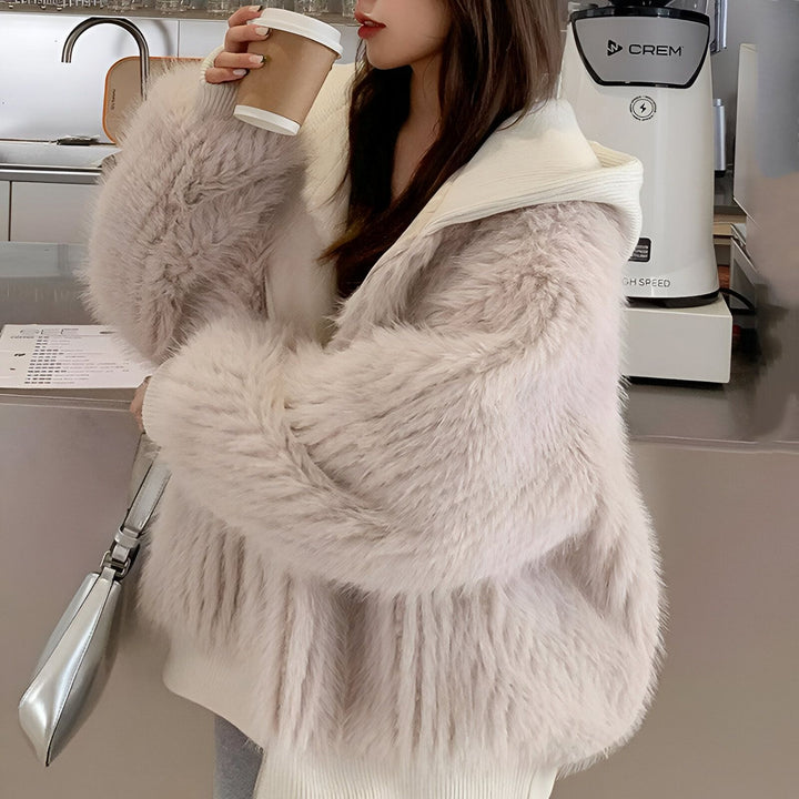Femme portant un kimono moderne en fausse fourrure avec capuche. Boisson chaude à la main. Vêtements de style kimono tendance.