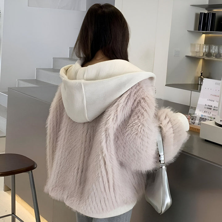 Dos d'une femme portant un kimono à capuche en fausse fourrure beige et blanche. Vêtements kimono tendance.