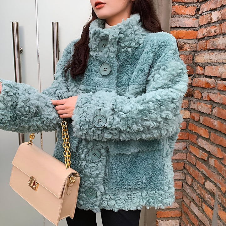 Manteau kimono turquoise texturé avec boutons sur mannequin, sac beige.