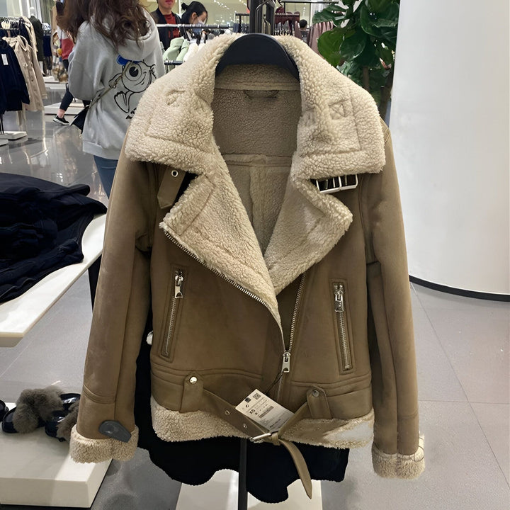 Veste aviateur en suédine marron clair avec col en fausse fourrure crème, fermeture éclair asymétrique et ceinture. Vêtement d'extérieur de mode pour femme.