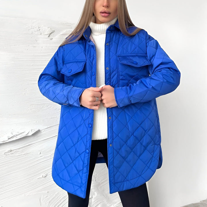Femme portant une veste matelassée bleue style kimono. Veste à poches boutonnée, idéale pour un look décontracté et tendance. Parfait pour compléter votre garde-robe kimono!