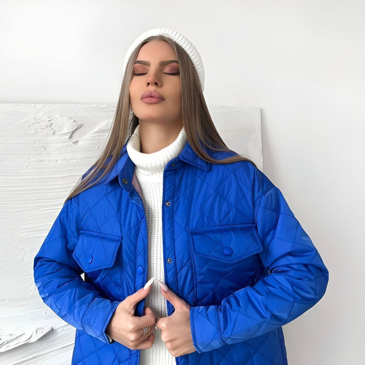 Femme portant une veste kimono matelassée bleue, un pull col roulé blanc et un bonnet blanc. Style décontracté et tendance. Collection de kimonos.