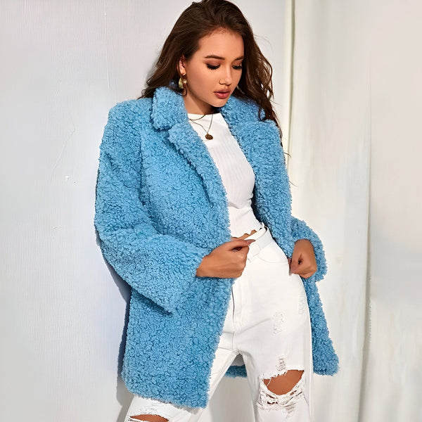Femme portant un manteau bleu en fausse fourrure et un jean déchiré blanc. Kimono d'hiver chaud et confortable, idéal pour la superposition.