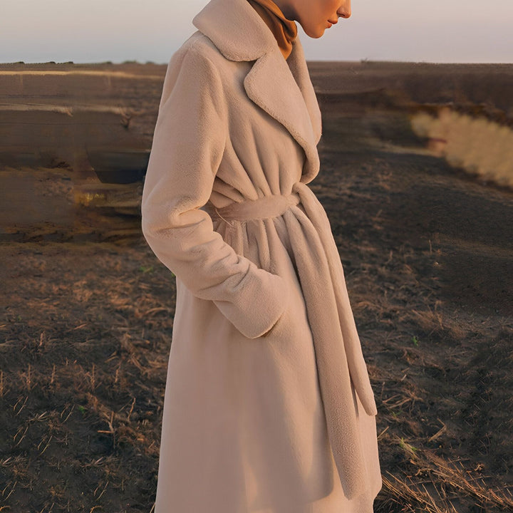 Femme portant un kimono beige à ceinture dans un paysage automnal. Élégance et confort, parfait pour les journées fraîches. Découvrez notre collection de kimonos uniques.
