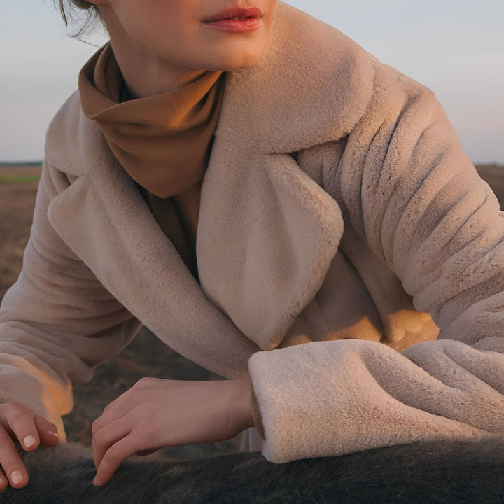 Femme portant un manteau beige, col roulé marron. Vêtements d'extérieur élégants et confortables. Collection de kimonos modernes. Mode automne-hiver. Style décontracté chic.