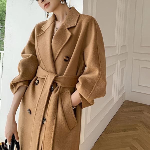 Femme portant un long manteau croisé camel, cinturé. Vêtements de style kimono disponibles.