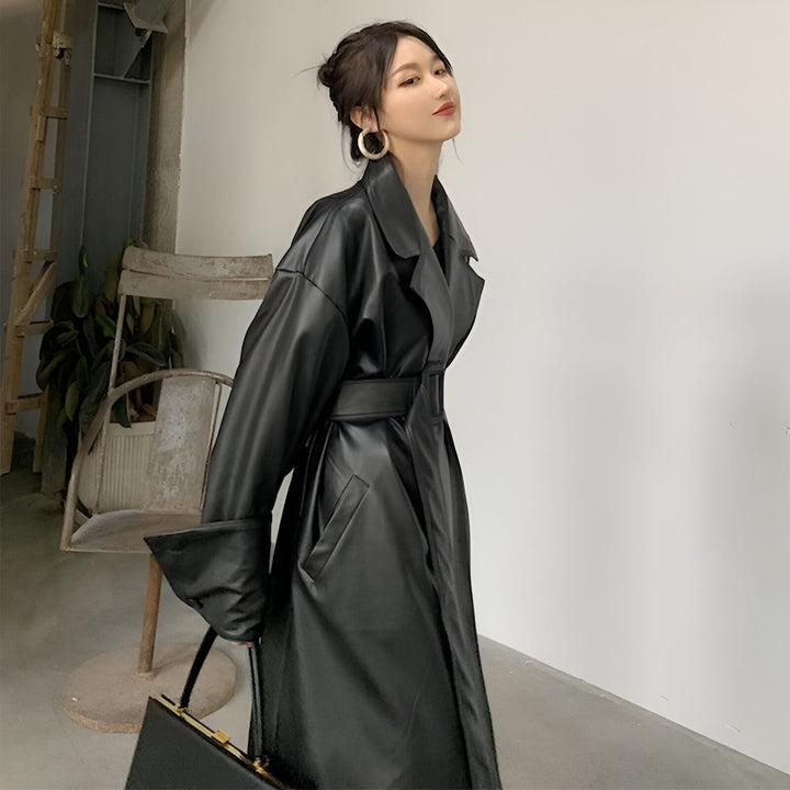 Femme portant un kimono noir en cuir, avec ceinture. Kimono long et élégant. Collection de kimonos en cuir disponibles.