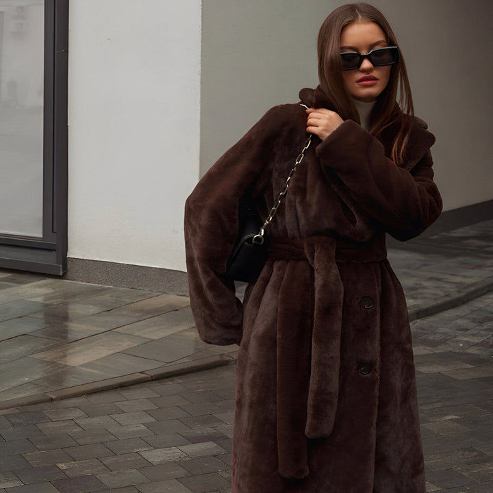 Femme élégante portant un kimono long marron en fausse fourrure avec ceinture et lunettes de soleil noires. Mode kimono d'hiver. Découvrez notre collection de kimonos uniques.
