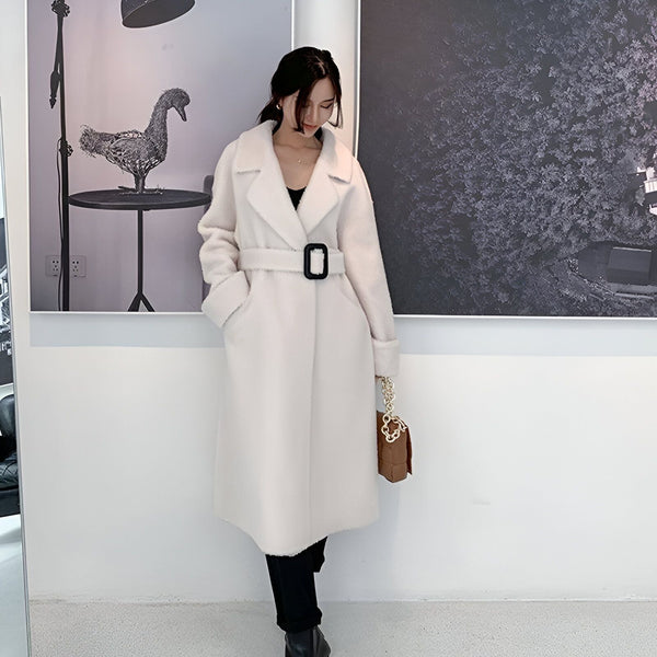 Femme portant un long kimono blanc avec ceinture à boucle noire. Vêtements d'hiver élégants. Accessoire de mode: sac à main marron. Disponible dans notre boutique de kimonos.