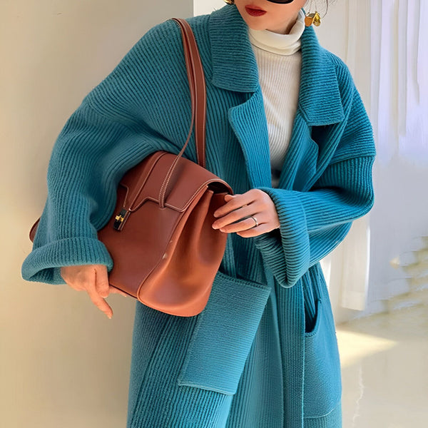 Femme portant un kimono bleu en tricot avec un sac en cuir marron. Vêtements de style kimono à vendre.