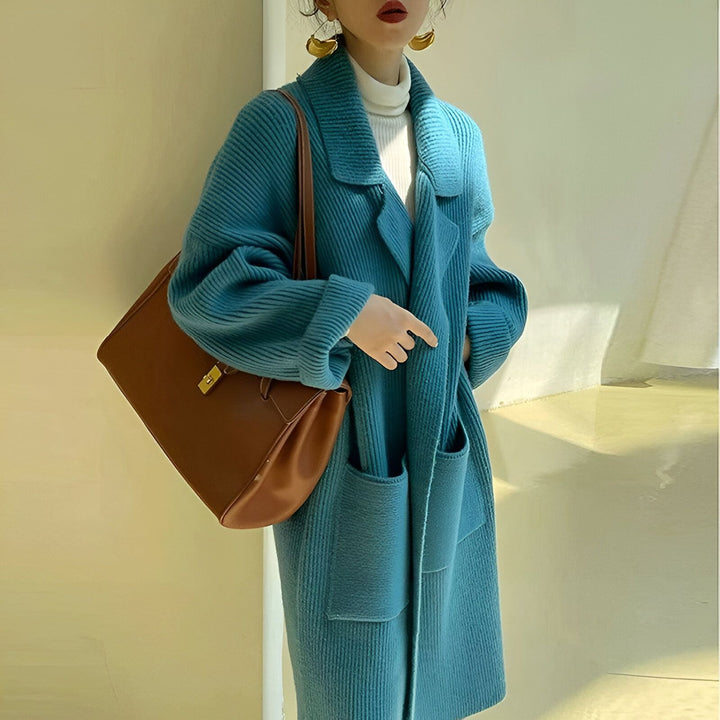 Femme portant un long cardigan en tricot bleu turquoise, avec un sac à main marron. Vêtements de style kimono pour femmes.