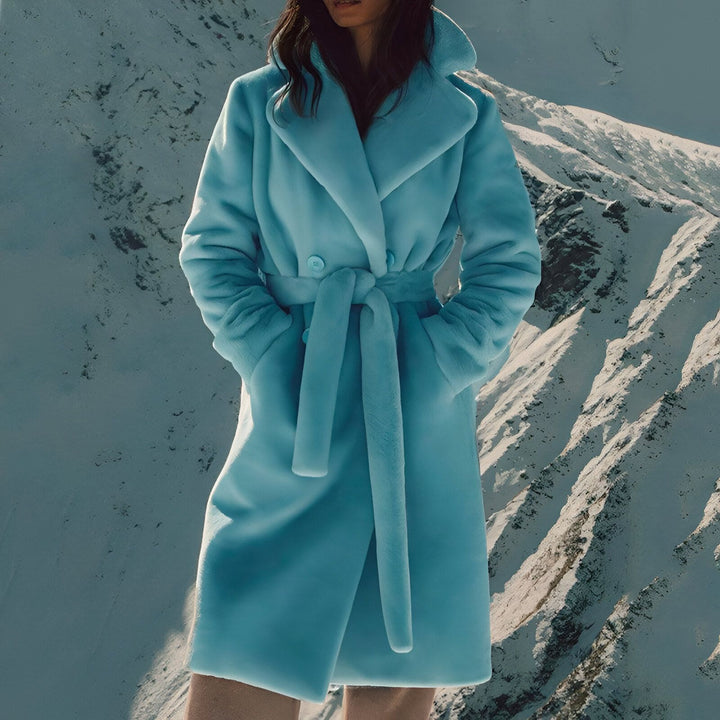 Femme portant un kimono bleu ciel à ceinture devant un paysage montagneux enneigé. Vente de kimonos en ligne.