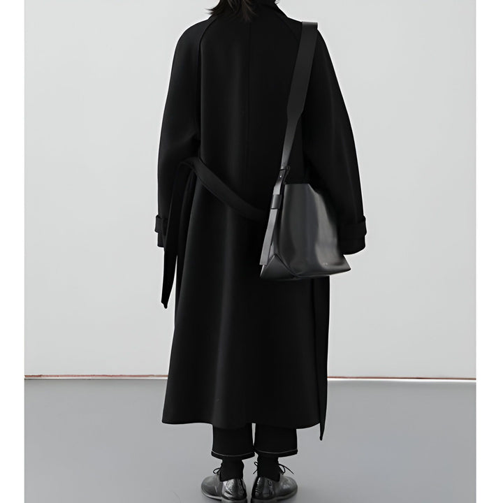 Dos d'une personne portant un kimono noir long avec une ceinture et un sac à main en cuir noir. Vêtements kimono élégants et modernes. Boutique de kimonos.