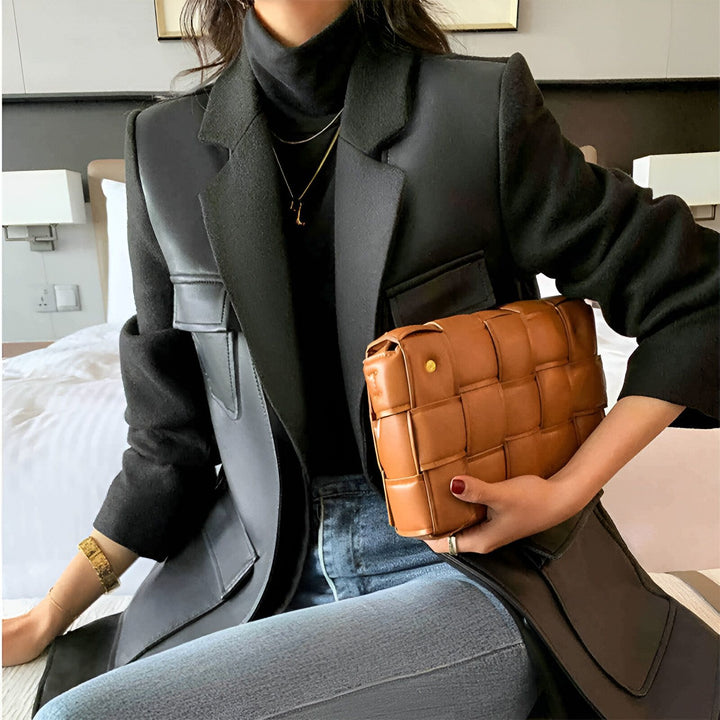 Femme portant un kimono noir moderne avec un sac à main en cuir tressé marron. Vêtements de style japonais chics et contemporains. Découvrez notre collection de kimonos uniques !