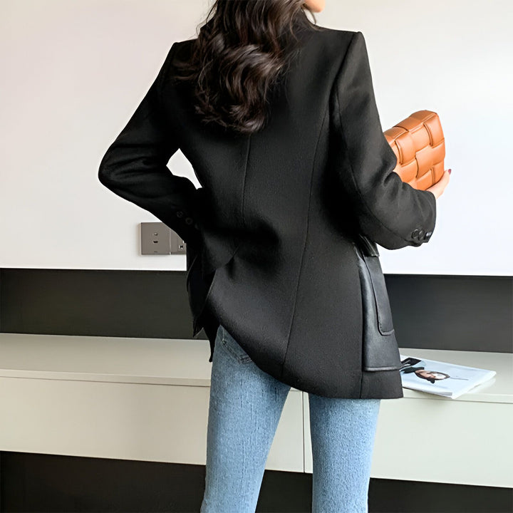 Dos d'une femme portant un blazer noir, un jean bleu et tenant un sac en cuir tressé. Vêtements de style kimono disponibles sur notre boutique. Mode japonaise contemporaine.