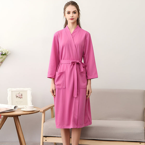 Femme portant un kimono rose avec ceinture. Peignoir kimono de notre collection, idéal pour la maison ou comme vêtement d'intérieur. Achetez votre kimono préféré en ligne.