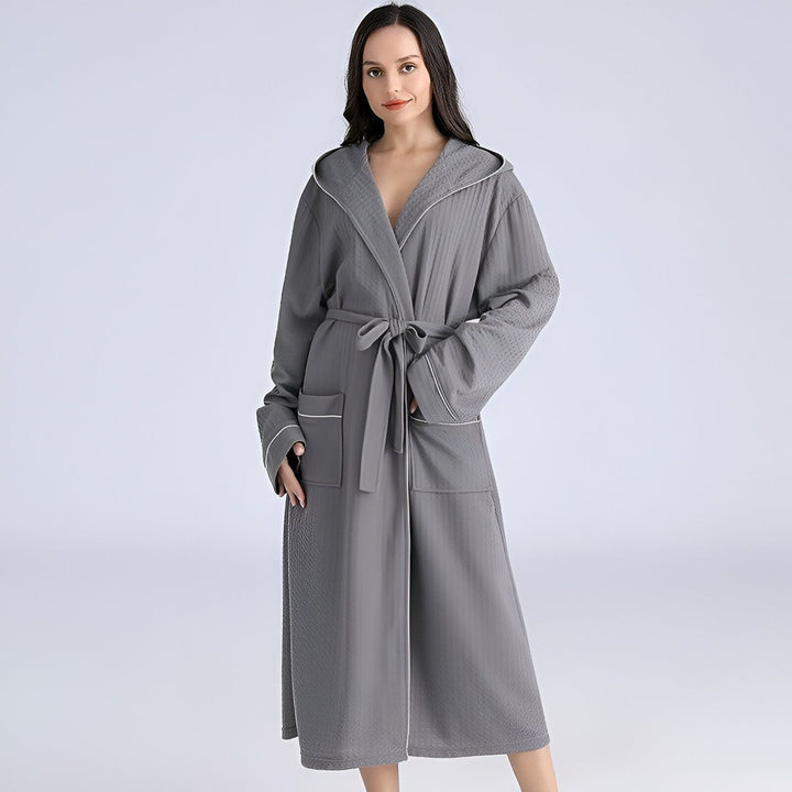 Femme portant un kimono long gris avec capuche et ceinture. Idéal comme peignoir ou vêtement de détente. Boutique de kimonos en ligne.