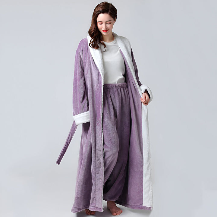 Femme portant un kimono long en velours violet avec intérieur blanc. Peignoir kimono confortable, idéal pour la détente à la maison. Collection de kimonos doux et élégants.