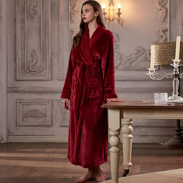 Femme portant un kimono rouge en velours doux avec ceinture. Kimono long avec poches, idéal pour se détendre à la maison. Vêtements de détente confortables et élégants.