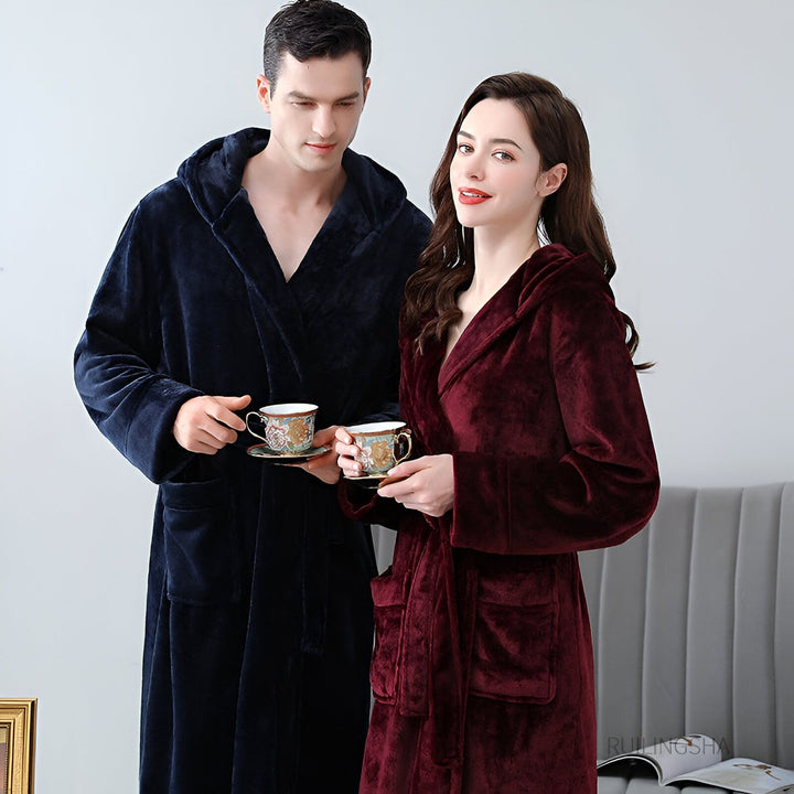 Couple portant des kimonos confortables avec capuche, bleu marine et bordeaux, tenant des tasses de thé. Collection de kimonos de qualité supérieure pour un style décontracté et élégant à la maison. Découvrez nos peignoirs kimonos doux et luxueux.