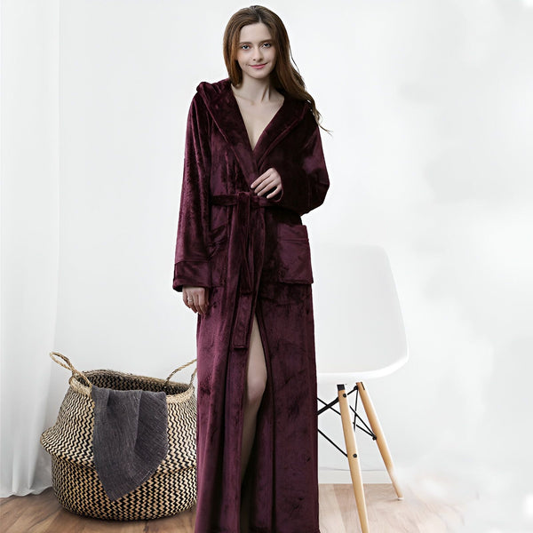 Femme portant un long kimono bordeaux à capuche avec ceinture. Peignoir d'intérieur en velours, confortable et élégant. Vêtements japonais de détente.