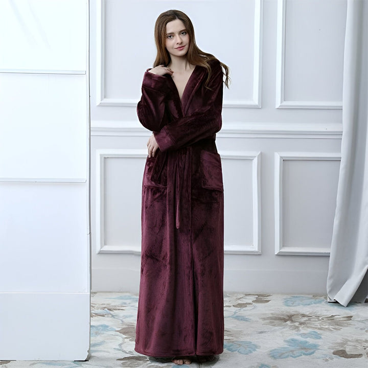 Femme portant un long kimono bordeaux en velours. Kimono confortable avec poches, idéal pour se détendre à la maison. Découvrez notre collection de kimonos de luxe.