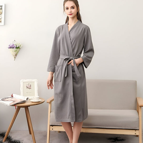 Femme portant un kimono gris confortable avec ceinture. Peignoir élégant pour la maison. Collection de kimonos doux et relaxants.