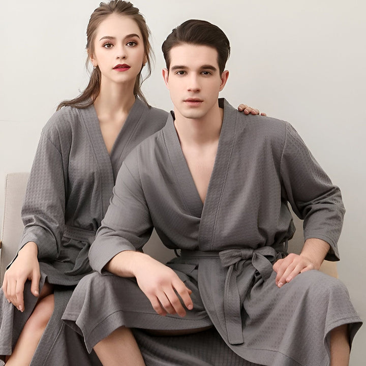 Couple portant des kimonos assortis gris. Kimonos confortables à motifs gaufrés, parfaits pour la détente à la maison. Vente de kimonos pour hommes et femmes.