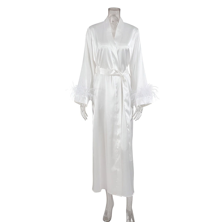 Kimono blanc en satin avec plumes aux manches. Peignoir élégant, idéal comme vêtement de détente ou pour une occasion spéciale. Découvrez notre collection de kimonos de luxe.