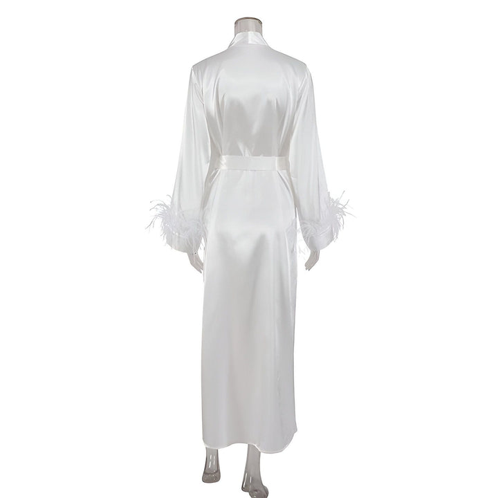 Kimono long en satin blanc avec ceinture et plumes sur les manches. Vue de dos. Parfait comme vêtement de détente élégant ou peignoir de luxe.