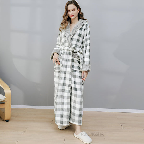Femme portant un kimono à carreaux gris et blanc avec capuche bordée de fourrure grise. Peignoir kimono confortable et élégant.