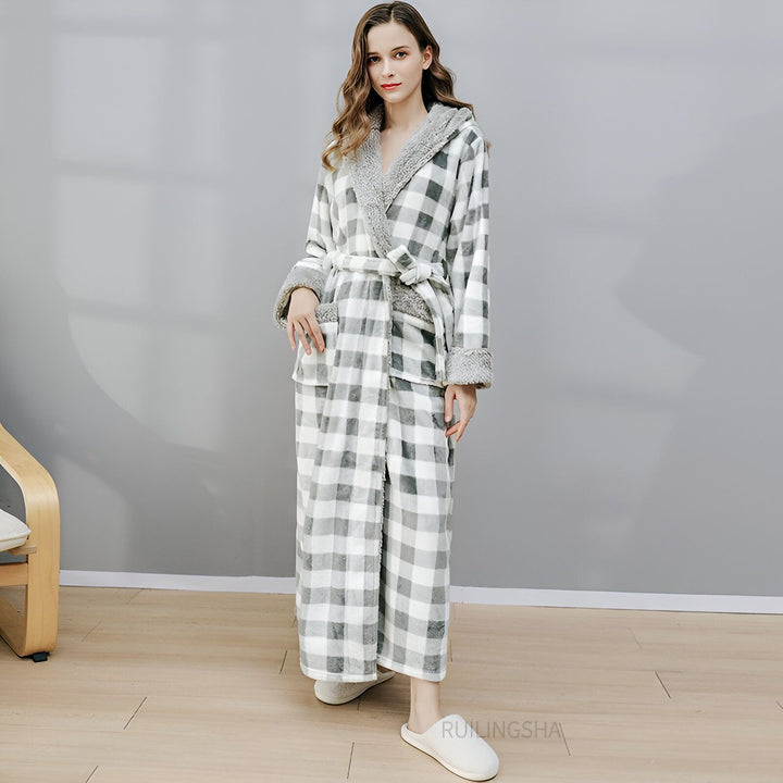 Femme portant un kimono à carreaux gris et blanc avec capuche bordée de fourrure grise. Peignoir kimono confortable et élégant.