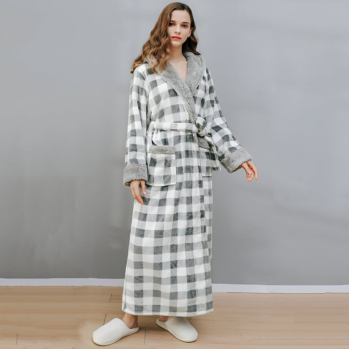 Femme portant un long kimono à carreaux gris et blancs avec capuche et ceinture. Peignoir confortable idéal pour la détente à la maison. Disponible sur notre boutique en ligne de kimonos.