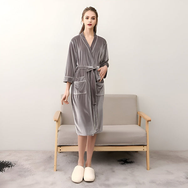 Femme portant un kimono gris en velours avec ceinture et poches. Peignoir kimono confortable et élégant. Vêtements d'intérieur relaxants.