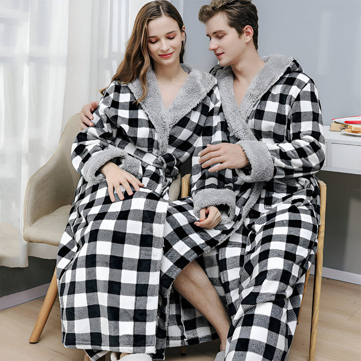 Couple portant des kimonos à carreaux noirs et blancs avec capuche et bordure en fourrure grise. Kimonos confortables pour la maison.