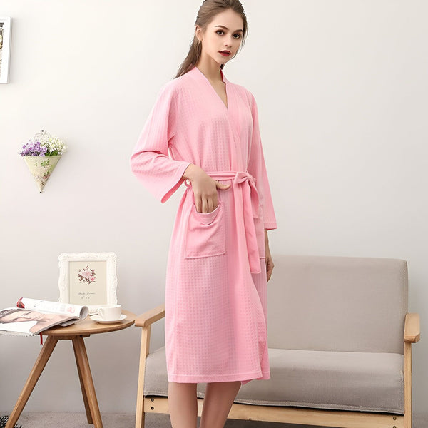 Femme portant un kimono rose confortable avec ceinture. Notre boutique propose une large sélection de kimonos élégants.